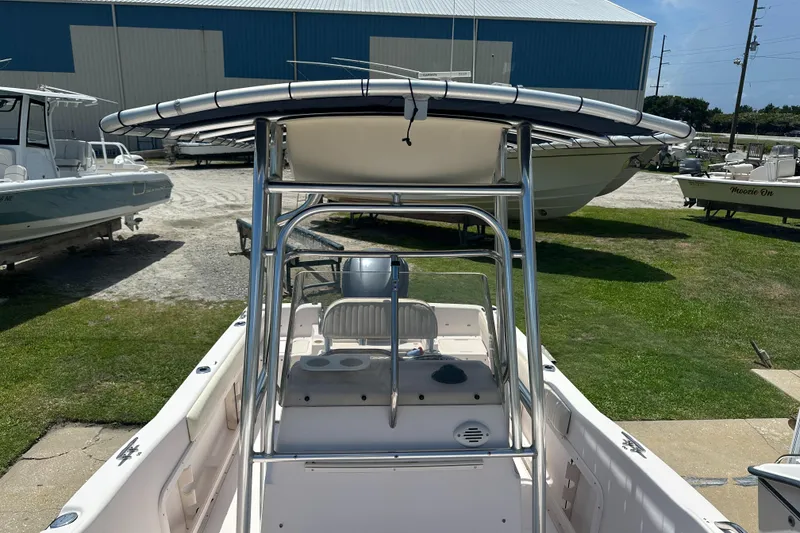 Slide: The Image of 2005 Grady-White Escape 209 boat with T-top, parked outdoors near other boats. - 13