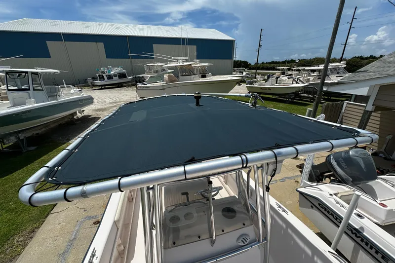 Slide: The Image of 2005 Grady-White Escape 209 boat with T-top cover in a marina setting. - 14