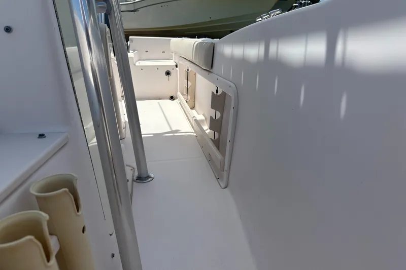 Slide: The Image of 2005 Grady-White Escape 209 boat interior with rod holders and seating area. - 17