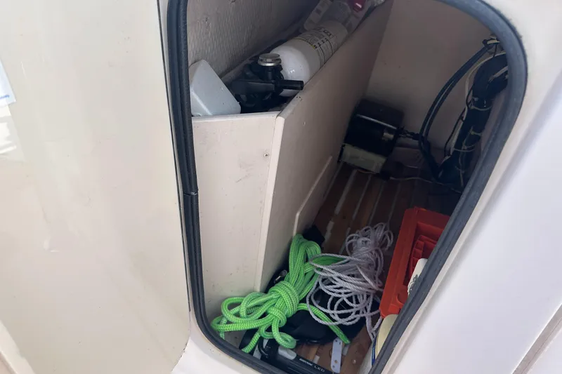 Slide: The Image of Storage compartment of a 2005 Grady-White Escape 209 boat with ropes and equipment. - 19
