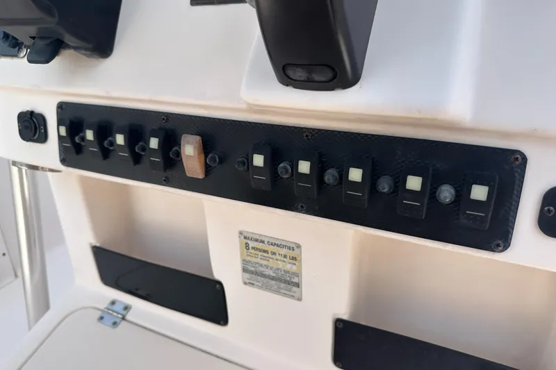 Slide: The Image of Control panel of a 2005 Grady-White Escape 209 boat with multiple switches. - 30
