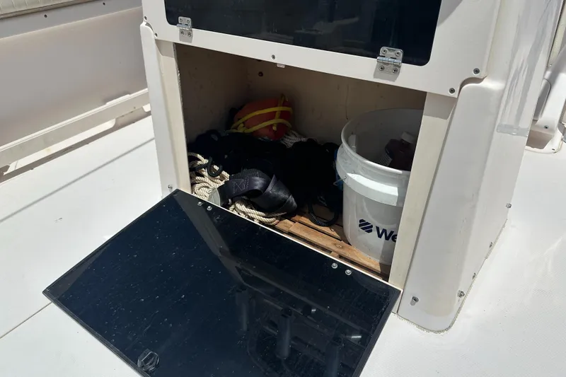 Slide: The Image of Open storage compartment on 2005 Grady-White Escape 209 boat with ropes and a bucket. - 37