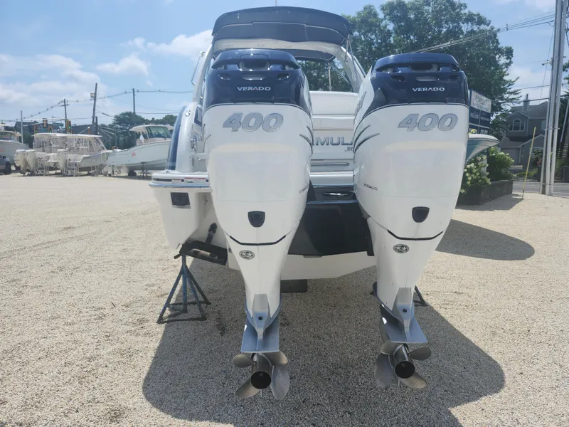 Slide: The Image of 2020 Formula 310 Sun Sport boat with twin Verado 400 engines, parked on gravel. - 13