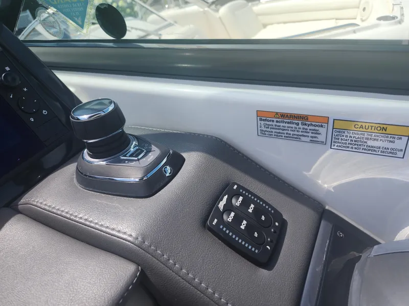 Slide: The Image of 2020 Formula 310 Sun Sport boat controls with joystick and warning labels. - 16