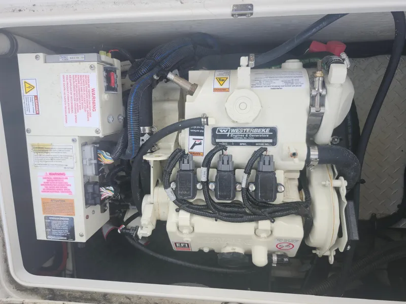 Slide: The Image of Engine compartment of a 2020 Formula 310 Sun Sport boat, featuring a Westerbeke generator. - 21