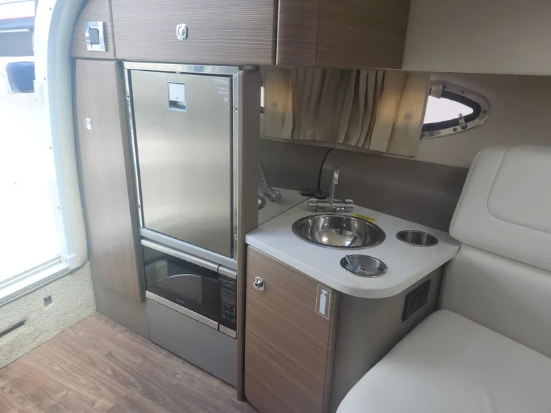 Slide: The Image of 2020 Formula 310 Sun Sport interior with kitchenette, featuring sink, fridge, and microwave. - 29