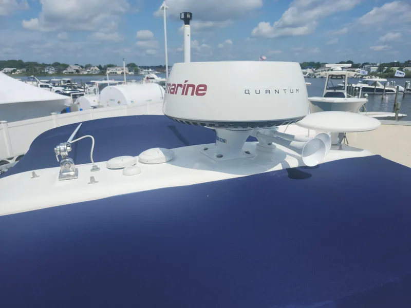 Slide: The Image of 2020 Formula 310 Sun Sport boat with radar equipment, docked at a marina under a cloudy sky. - 33