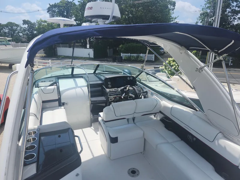 Slide: The Image of 2020 Formula 310 Sun Sport boat interior with white seating and blue canopy. - 8