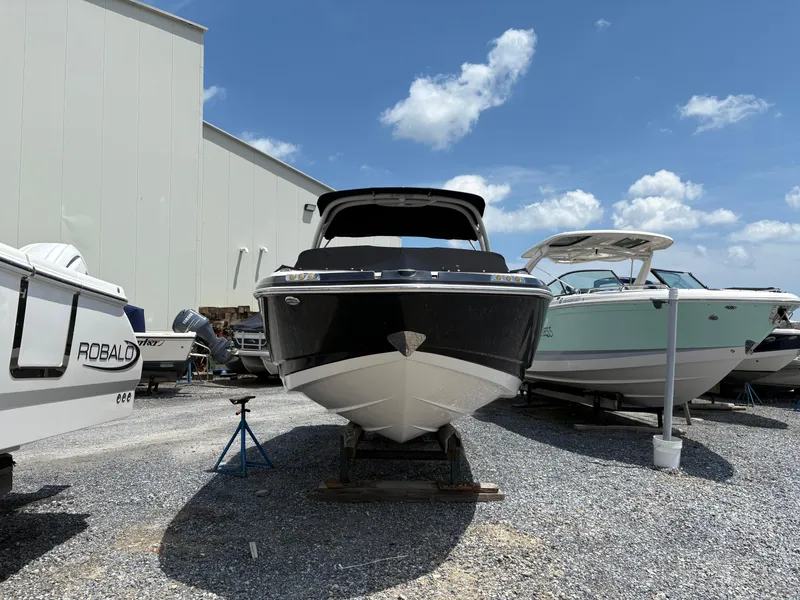 Slide: The Image of 2016 Chaparral 230 Suncoast boat on display outdoors under a clear blue sky. - 13