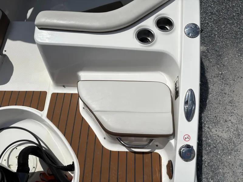 Slide: The Image of 2016 Chaparral 230 Suncoast boat interior with cushioned seating and cup holders. - 18