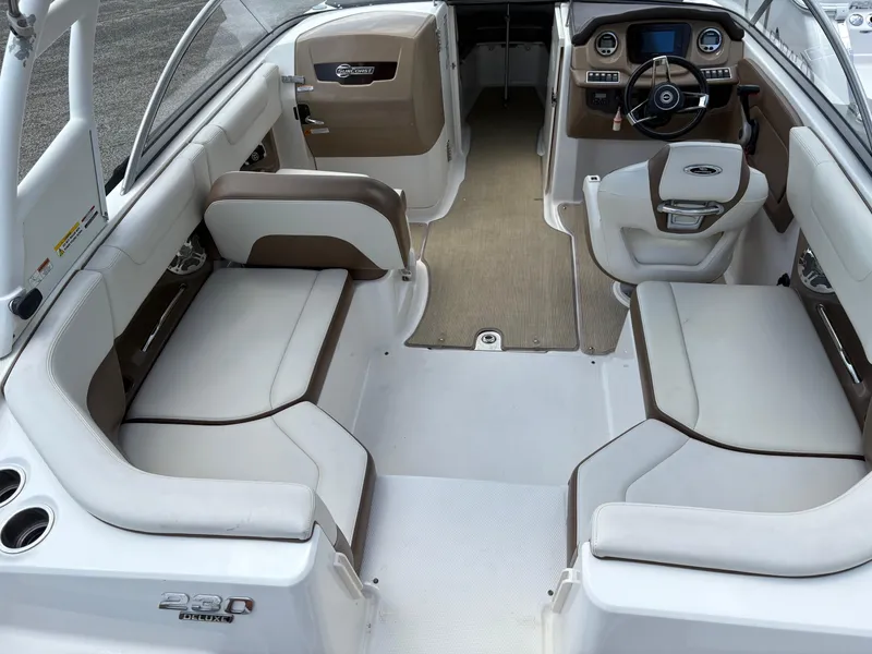 Slide: The Image of 2016 Chaparral 230 Suncoast boat interior with beige seating and modern dashboard. - 19