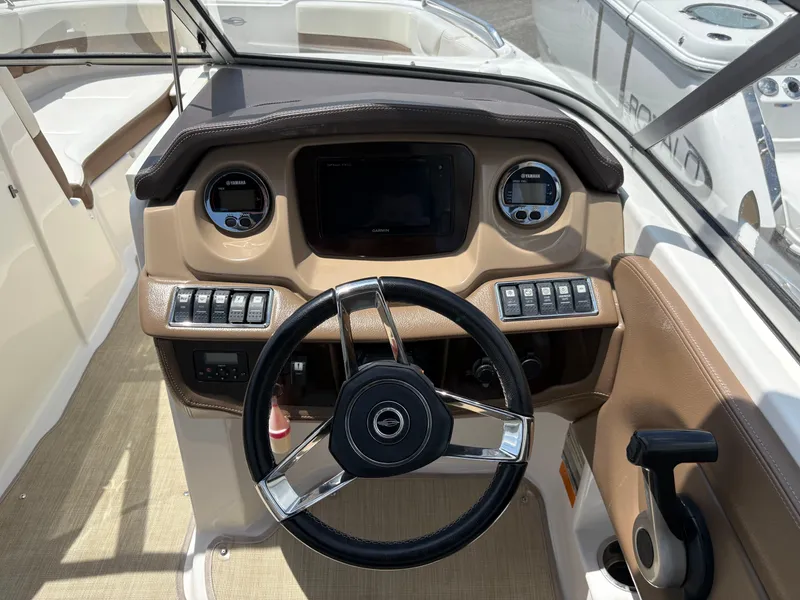 Slide: The Image of 2016 Chaparral 230 Suncoast boat dashboard with steering wheel and control panel. - 24