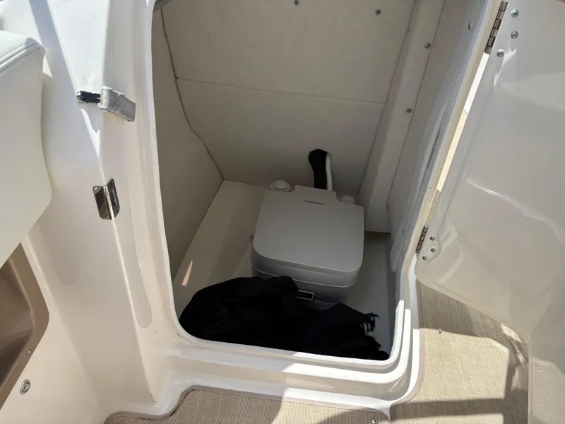 Slide: The Image of Portable toilet inside 2016 Chaparral 230 Suncoast boat compartment. - 32