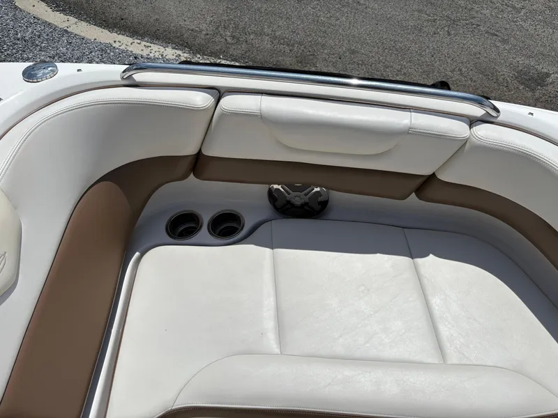Slide: The Image of 2016 Chaparral 230 Suncoast boat interior with white and tan seating, cup holders, and speaker. - 36