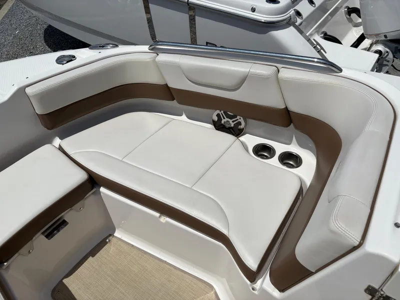 Slide: The Image of 2016 Chaparral 230 Suncoast boat interior with white and brown seating, cup holders, and speaker. - 38