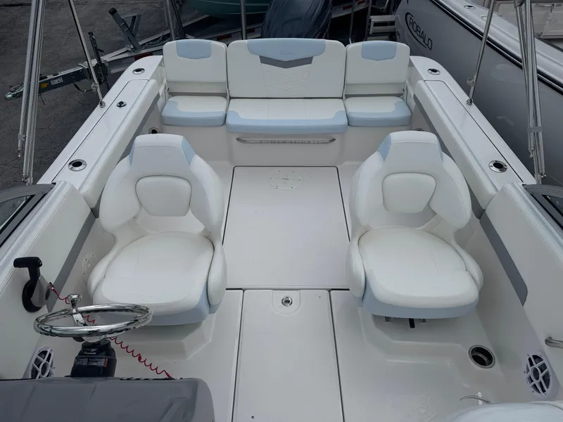 Slide: The Image of 2025 Robalo R207 Dual Console boat interior with white seating and steering wheel. - 11