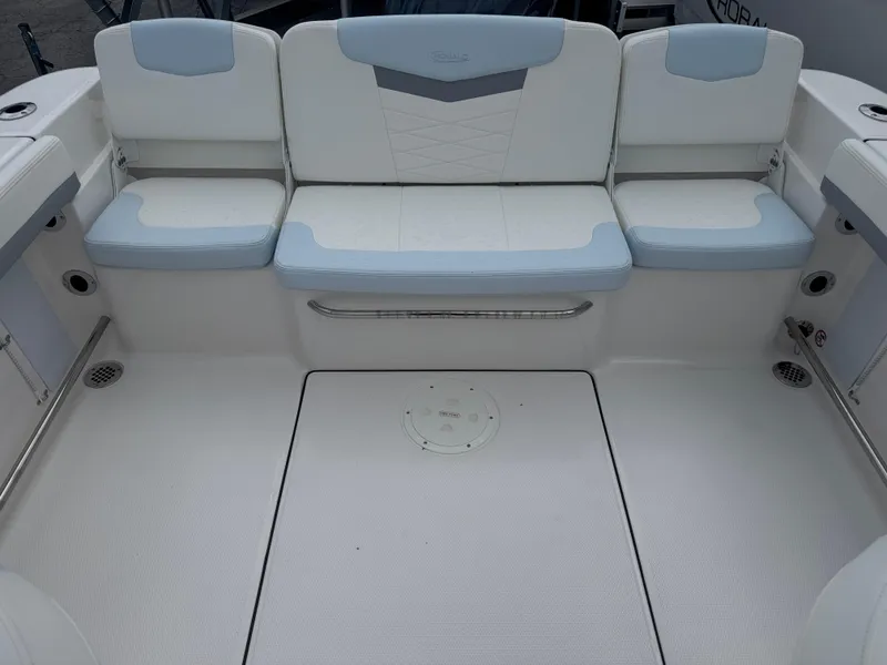 Slide: The Image of 2025 Robalo R207 Dual Console boat interior with white and blue seating. - 15