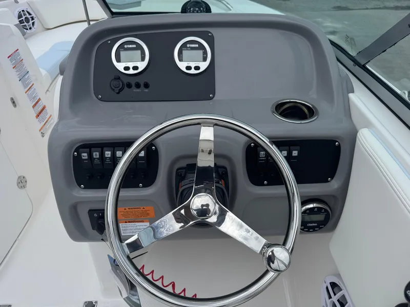 Slide: The Image of 2025 Robalo R207 Dual Console boat dashboard with steering wheel and Yamaha gauges. - 18