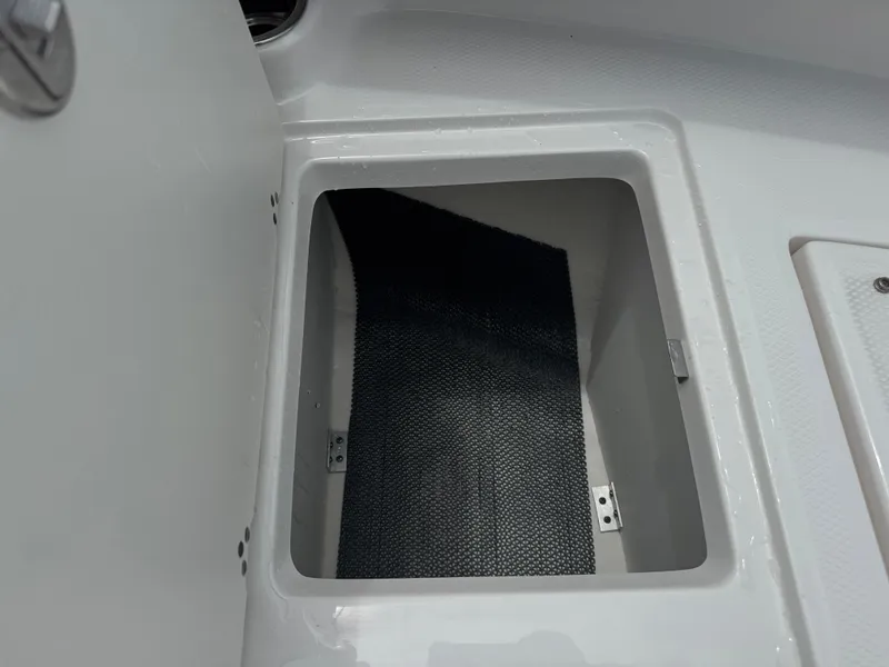 Slide: The Image of Storage compartment in 2025 Robalo R207 Dual Console boat, featuring a black mat. - 22