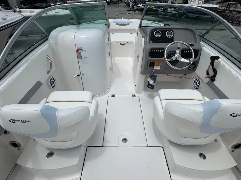 Slide: The Image of 2025 Robalo R207 Dual Console boat interior with white seating and modern dashboard. - 5