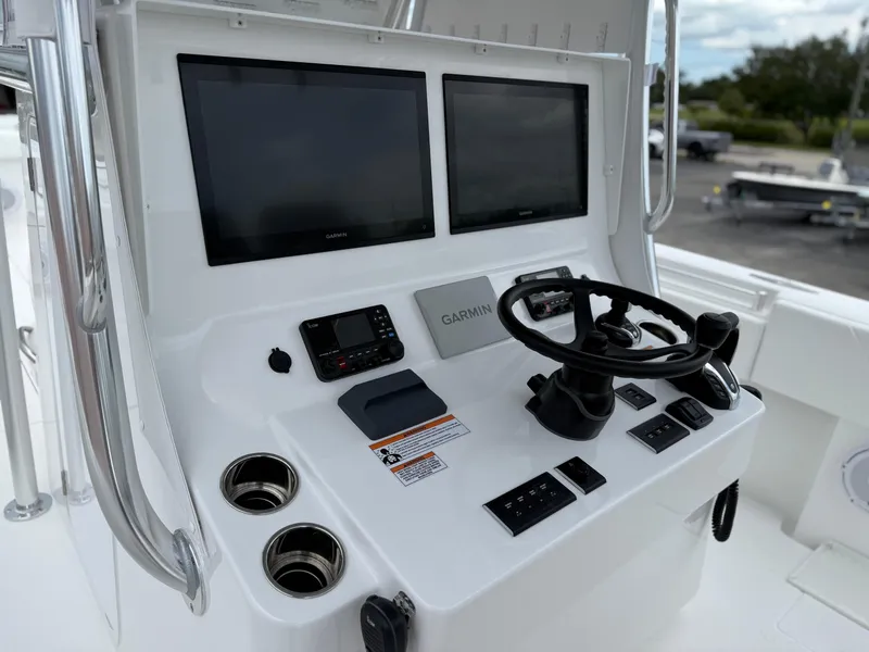 Slide: The Image of Control panel of 2026 Contender 39 ST boat with dual Garmin screens and steering wheel. - 11
