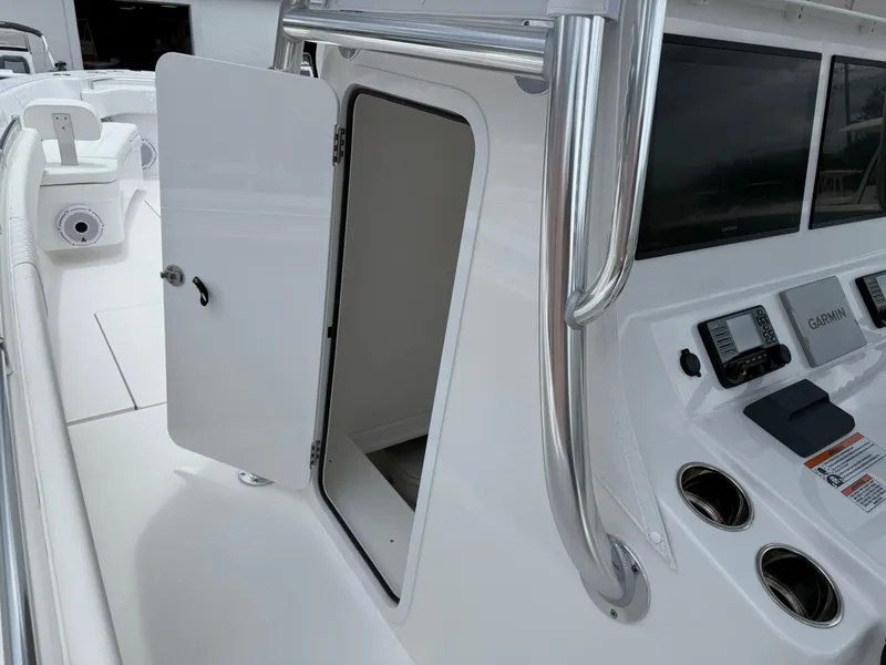 Slide: The Image of 2026 Contender 39 ST boat console with open storage door and Garmin electronics. - 22