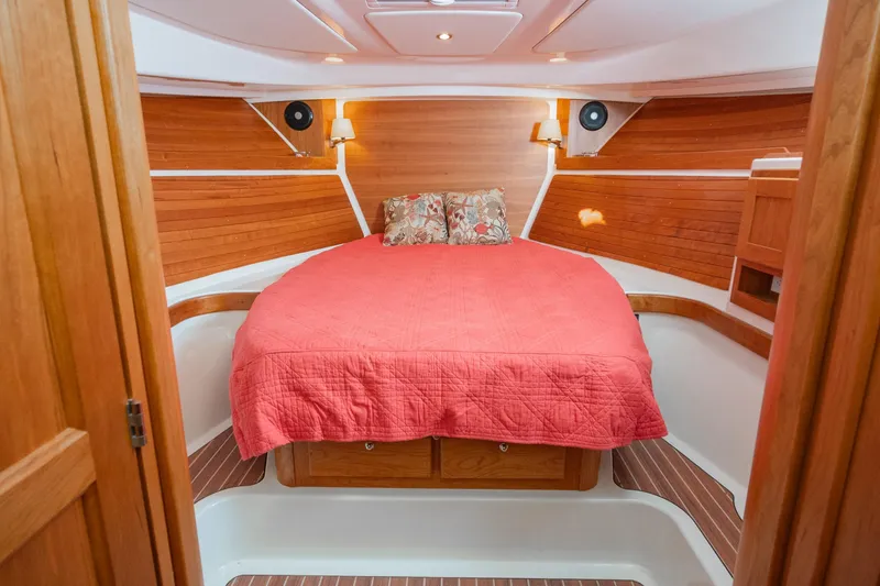 Slide: The Image of Luxurious cabin interior of 2026 Back Cove 34O with red bedding and wooden accents. - 11