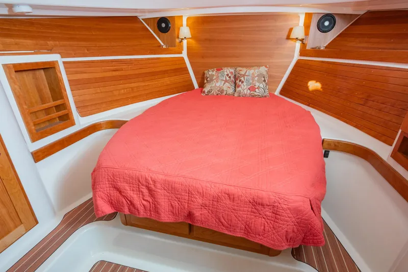 Slide: The Image of Luxurious cabin interior of 2026 Back Cove 34O with wood paneling and red bedding. - 12