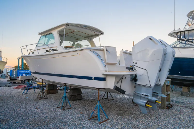 Slide: The Image of 2026 Back Cove 34O boat on stands, showcasing sleek design and powerful outboard engines. - 17