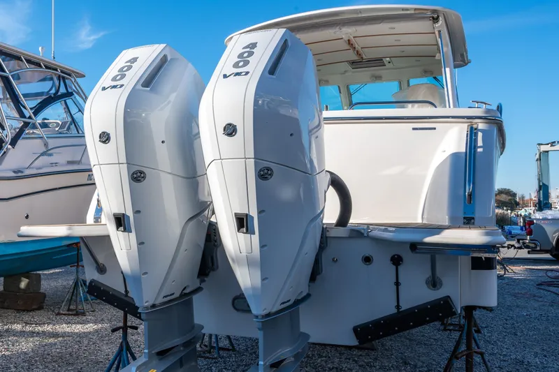 Slide: The Image of 2026 Back Cove 34O boat with dual 400 V10 engines, docked outdoors. - 18
