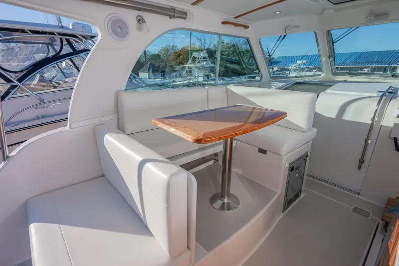 Slide: The Image of Interior of 2026 Back Cove 34O yacht with white seating and wooden table. - 7