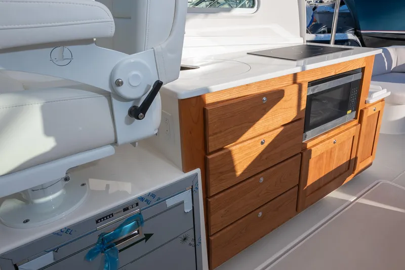 Slide: The Image of 2026 Back Cove 34O boat interior with wooden cabinetry and modern appliances. - 8