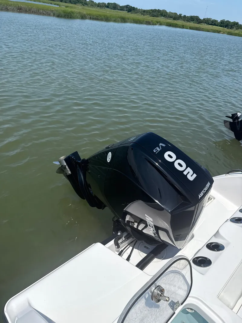 Slide: The Image of 2024 Aquasport 2200 Center Console boat with Mercury outboard motor on calm water. - 7