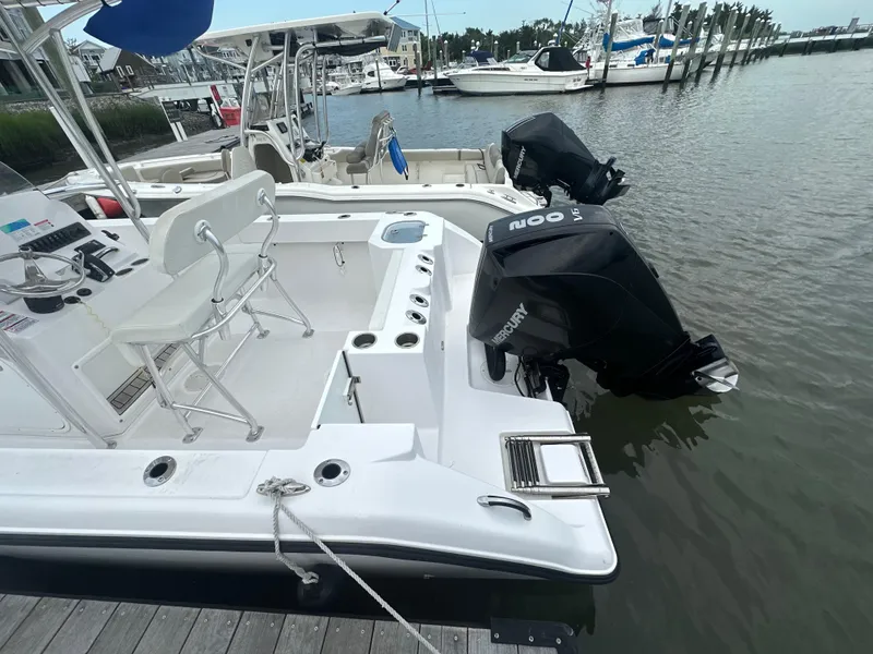 Slide: The Image of 2024 Aquasport 2200 Center Console boat docked with dual Mercury outboard engines. - 8