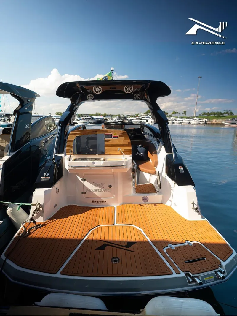Slide: The Image of 2025 NX Boats NX290 Exclusive, luxury boat docked with sleek design and wooden deck. - 8