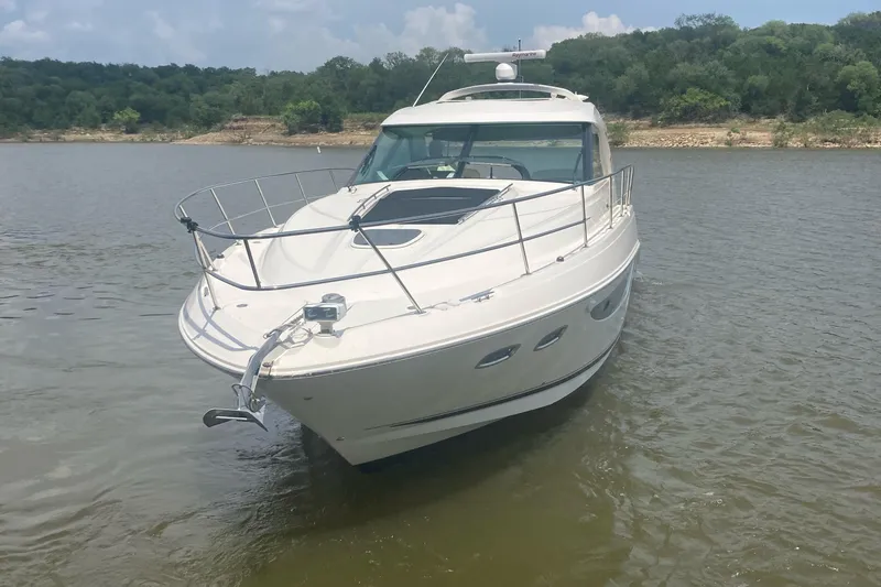 Slide: The Image of 2015 Sea Ray 450 Sundancer yacht on calm water, surrounded by lush greenery. - 2