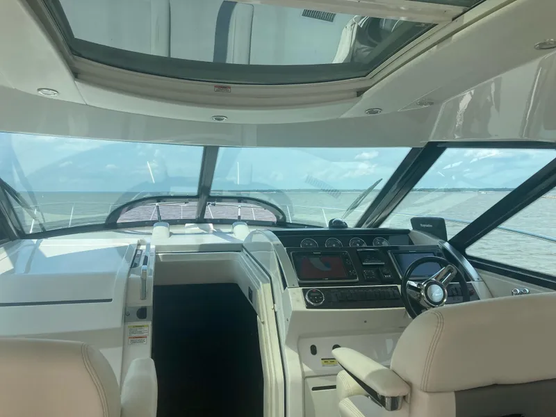Slide: The Image of Interior view of 2015 Sea Ray 450 Sundancer yacht cockpit with steering wheel and navigation controls. - 7