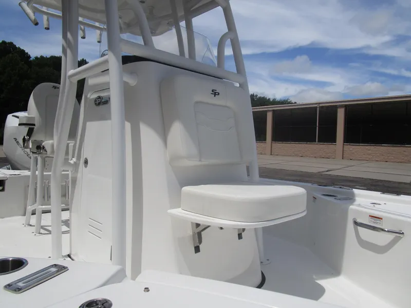 Slide: The Image of 2025 Sea Pro 230 DLX BAY boat interior with seating and console, under a clear sky. - 10