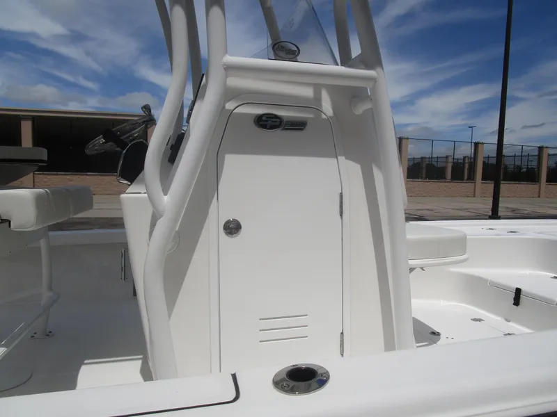 Slide: The Image of 2025 Sea Pro 230 DLX BAY boat interior with console and seating, under a clear blue sky. - 11