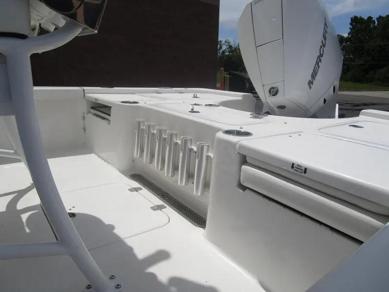 Slide: The Image of 2025 Sea Pro 230 DLX BAY boat interior with rod holders and Mercury engine. - 13