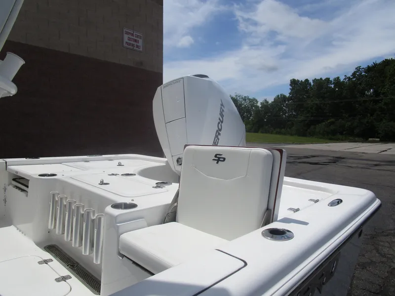 Slide: The Image of 2025 Sea Pro 230 DLX BAY boat with Mercury engine, white interior, and rod holders. - 4