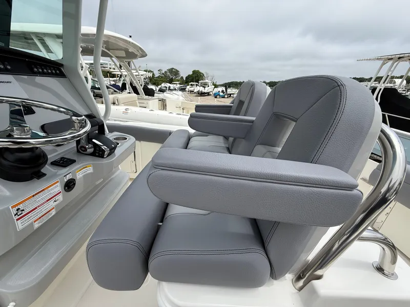 Slide: The Image of 2026 Boston Whaler 250 Outrage boat interior with gray seating and control panel. - 17