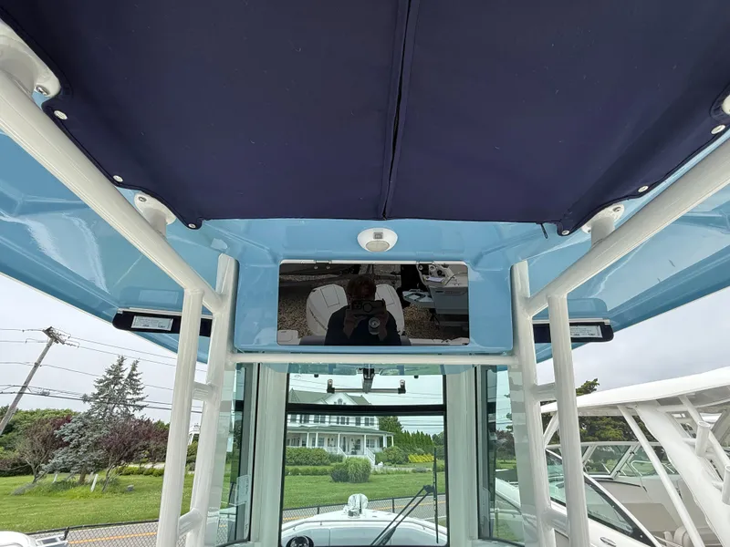 Slide: The Image of 2026 Boston Whaler 250 Outrage boat interior with blue canopy and console view. - 20