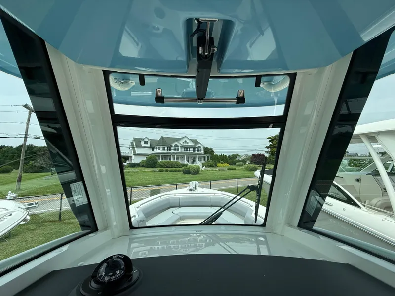 Slide: The Image of Interior view of 2026 Boston Whaler 250 Outrage boat, showcasing windshield and compass. - 22