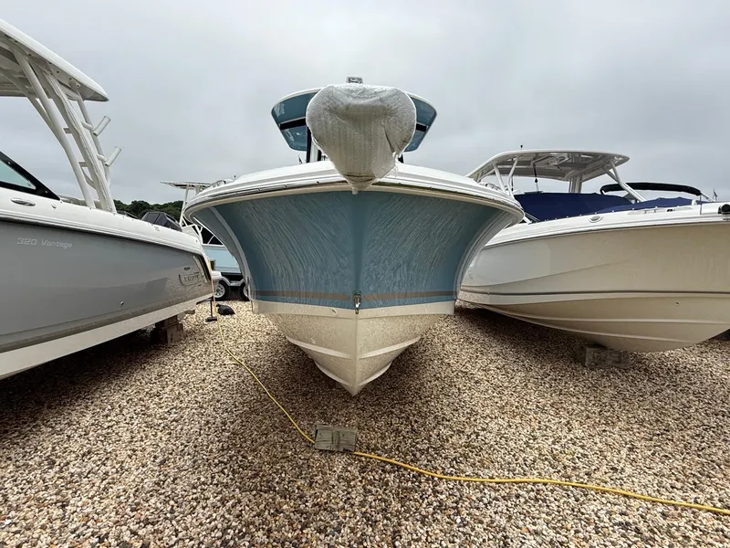 Slide: The Image of 2026 Boston Whaler 250 Outrage boat on gravel, flanked by other boats. - 36
