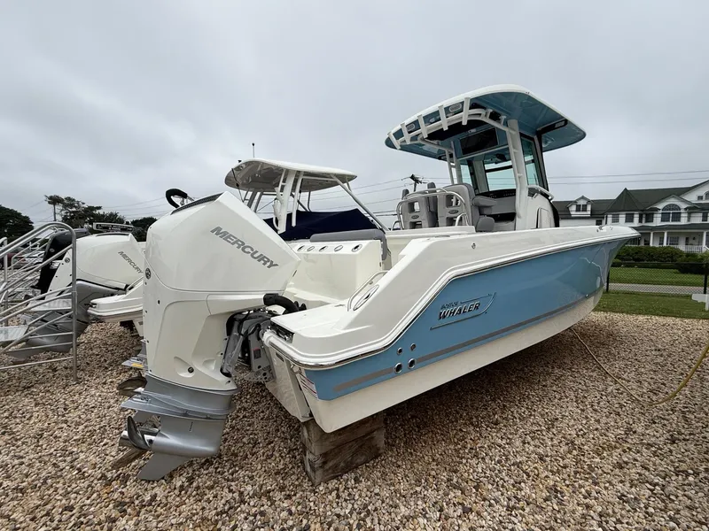 Slide: The Image of 2026 Boston Whaler 250 Outrage boat with Mercury engine on gravel lot. - 4