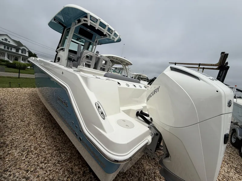 Slide: The Image of 2026 Boston Whaler 250 Outrage boat with Mercury engine, displayed on gravel. - 5