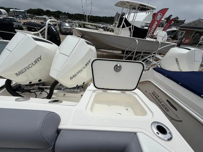 Slide: The Image of 2026 Boston Whaler 250 Outrage with dual Mercury engines, open storage compartment, and sleek design. - 9