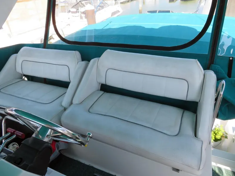 Slide: The Image of 1994 Carver 380 Santego boat interior with white seating and steering wheel. - 4