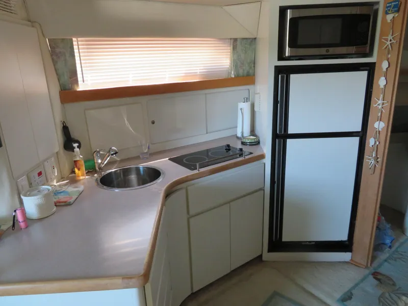 Slide: The Image of Compact kitchen in a 1994 Carver 380 Santego yacht with sink, stove, and microwave. - 9